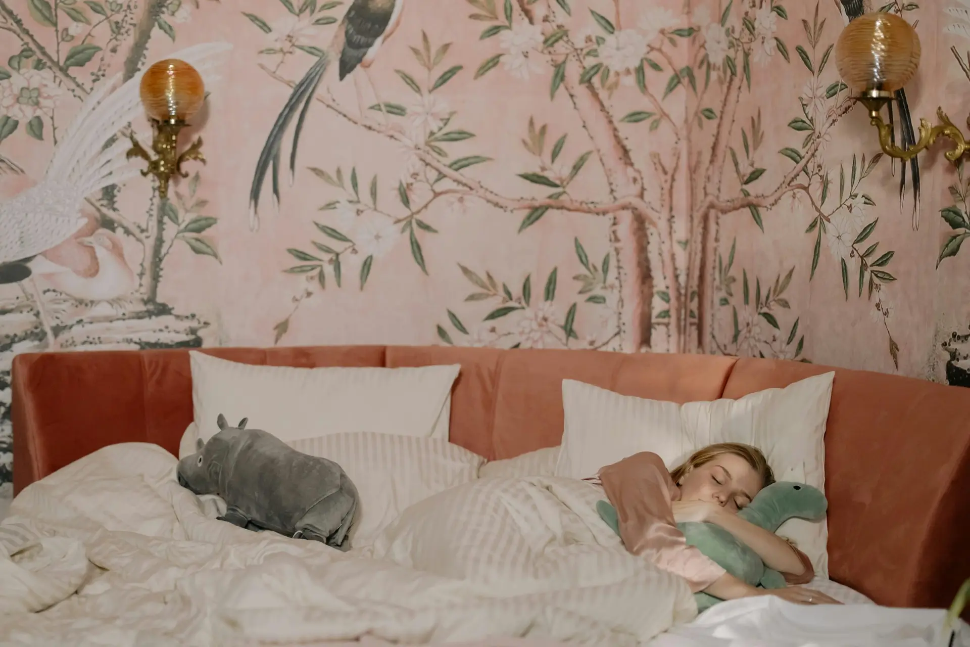 A child enjoying a peaceful nap with stuffed toys in a beautifully decorated bedroom.